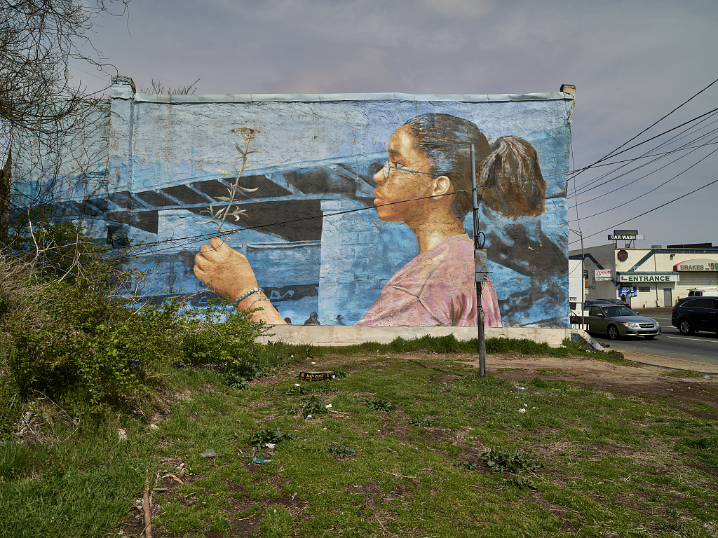 Community mural in Grays Ferry, a young girl holding a flower